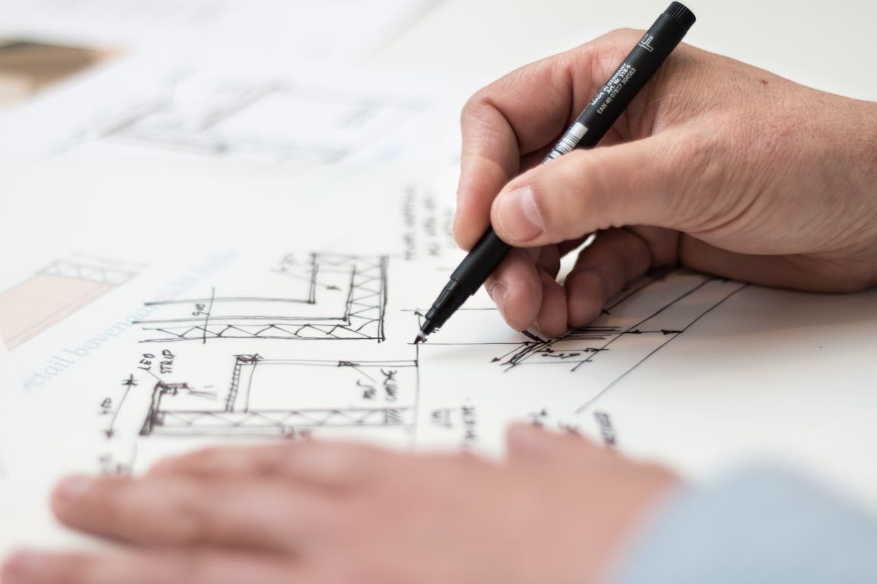 The Art of Drawing Readers In: Your attractive post title goes here Close-up of hand drawing intricate technical designs on blueprint with pen, ideal for engineering or architecture themes.